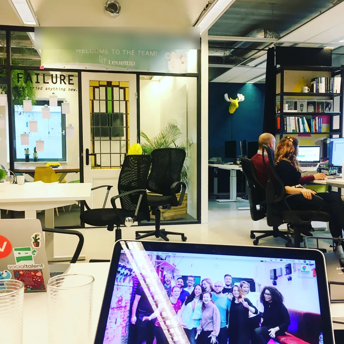 View over a laptop into a startup office on a first day
