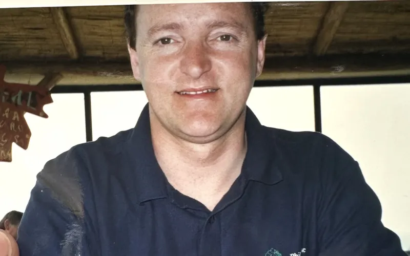 Ben's dad in a navy polo shirt, smiling at a table